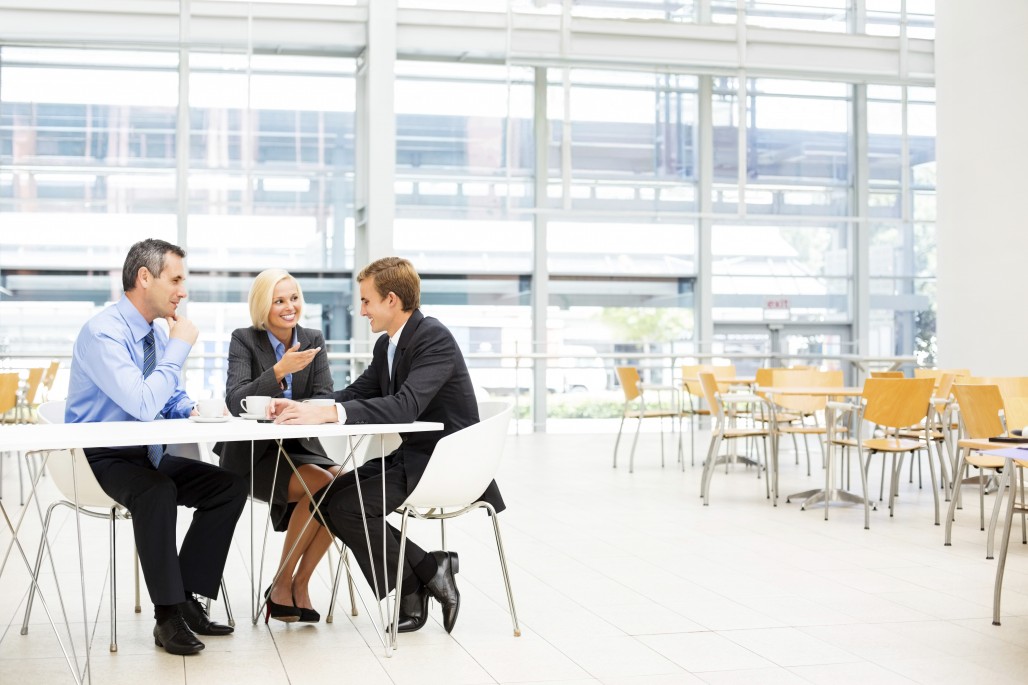 Full length of businesspeople in discussion during coffee break in cafeteria. Horizontal shot.