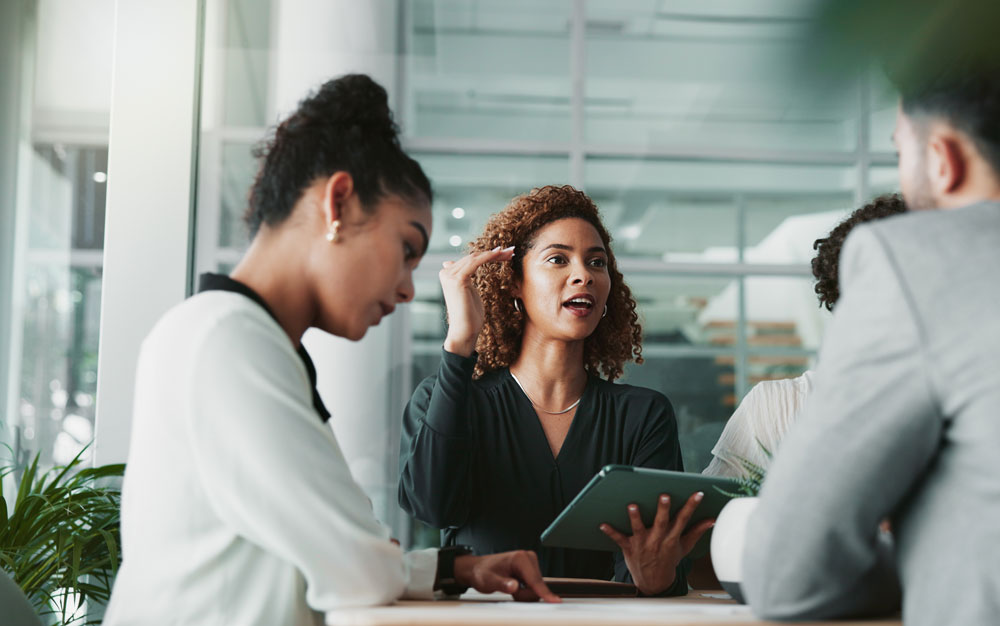 Women leading a meeting and indicating growth with her hand